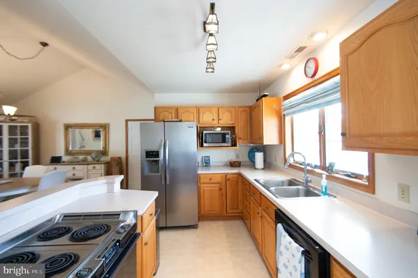 a kitchen with stainless steel appliances a sink a stove and a refrigerator