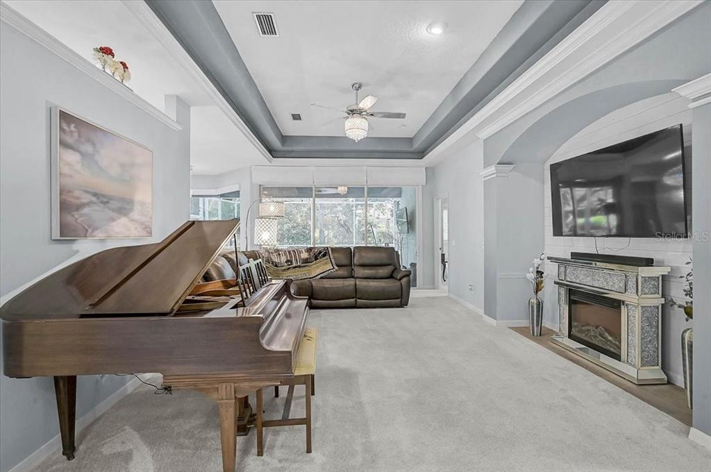 103 Bishopscourt Road Osprey, FL 34229 - Photo 6 of 55 a living room with furniture a flat screen tv and a fireplace