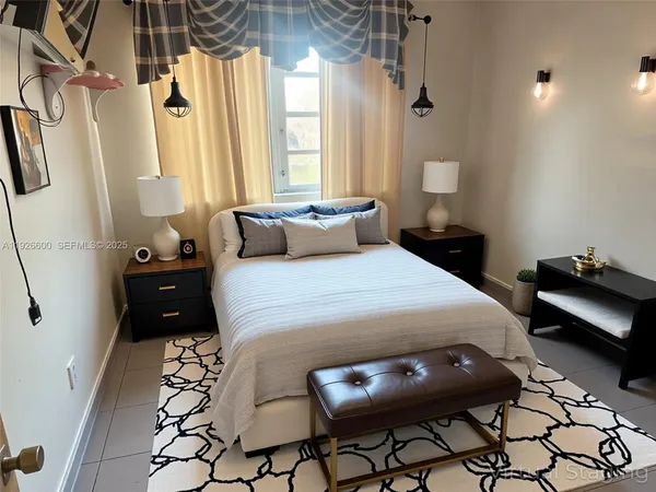 a bedroom with a bed a couch and a potted plant