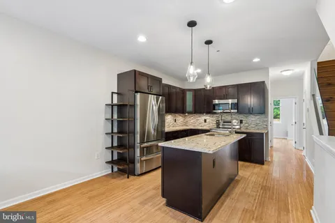 a kitchen with a refrigerator a stove top oven a sink dishwasher and wooden floor
