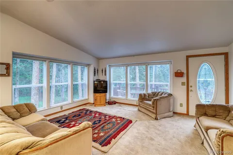 a living room with furniture and a floor to ceiling window