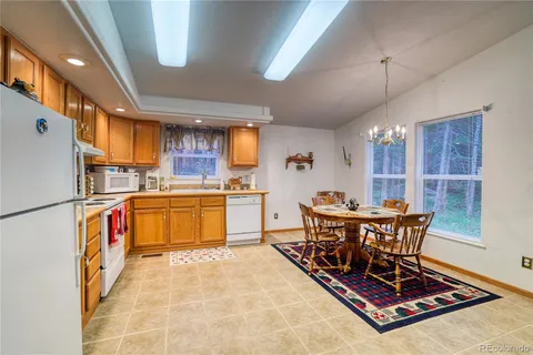 a kitchen with a table chairs refrigerator and cabinets