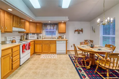 a kitchen with stainless steel appliances granite countertop a sink a stove and a refrigerator