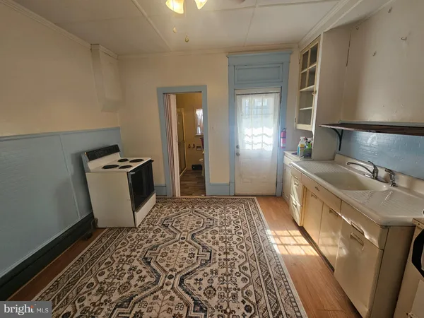 a kitchen with granite countertop a sink stove and refrigerator