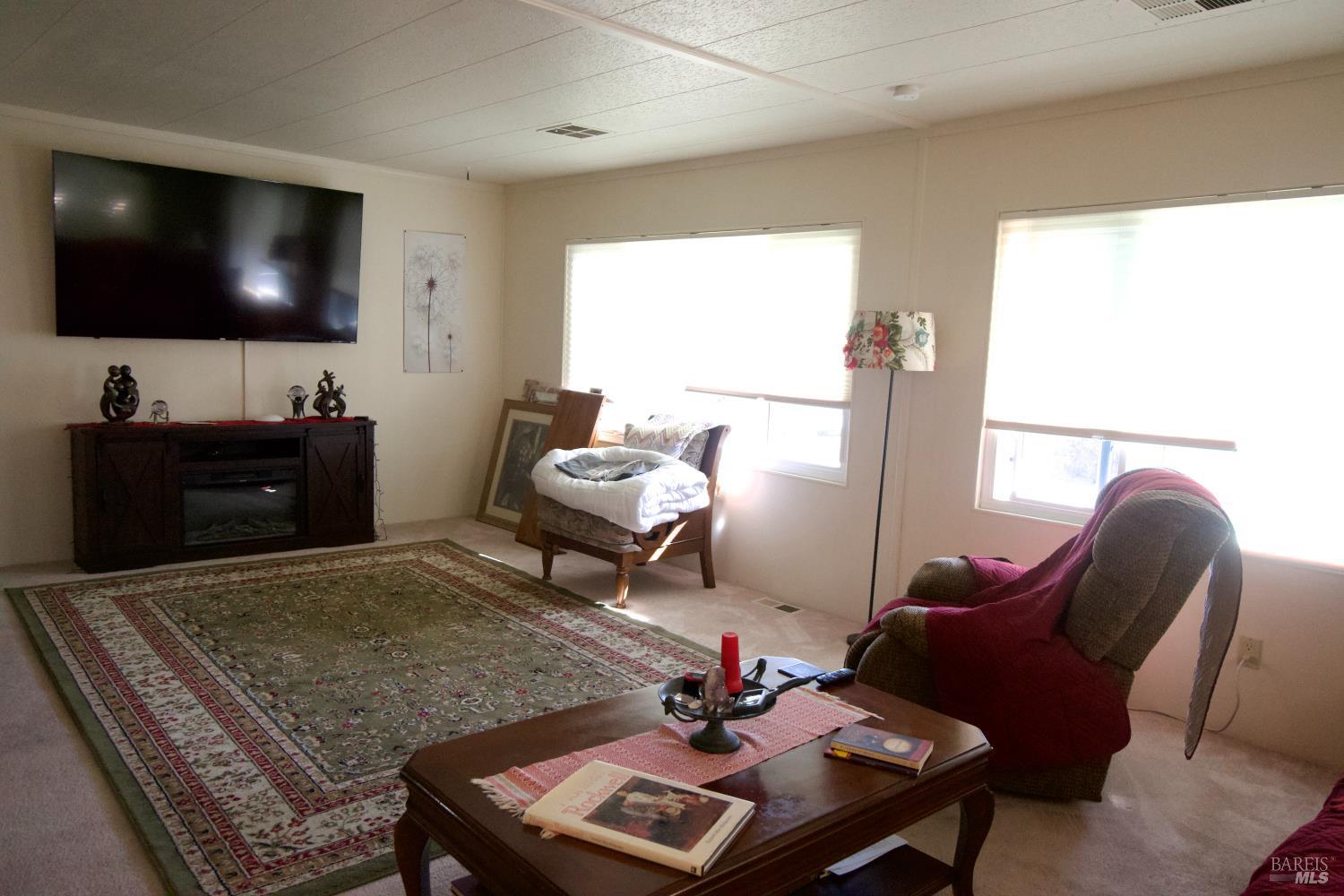 41 Plymouth Way Santa Rosa, CA 95403 - Photo 5 of 28 Light and bright living room. Large TV on wall goes with the home.