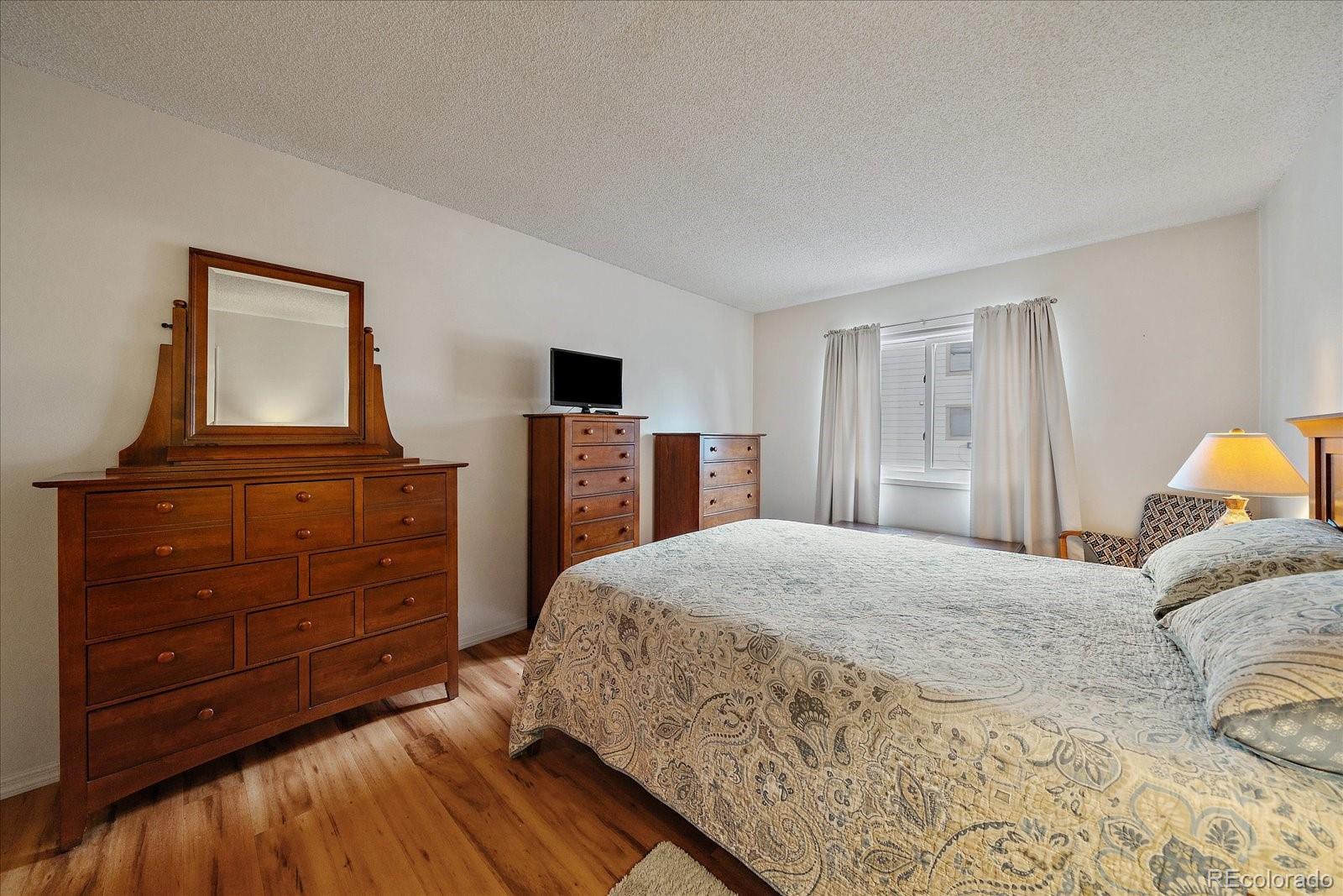 471 South Kalispell Way, Unit 101 Aurora, CO 80017 - Photo 11 of 27 a bedroom with a bed and a dresser in it