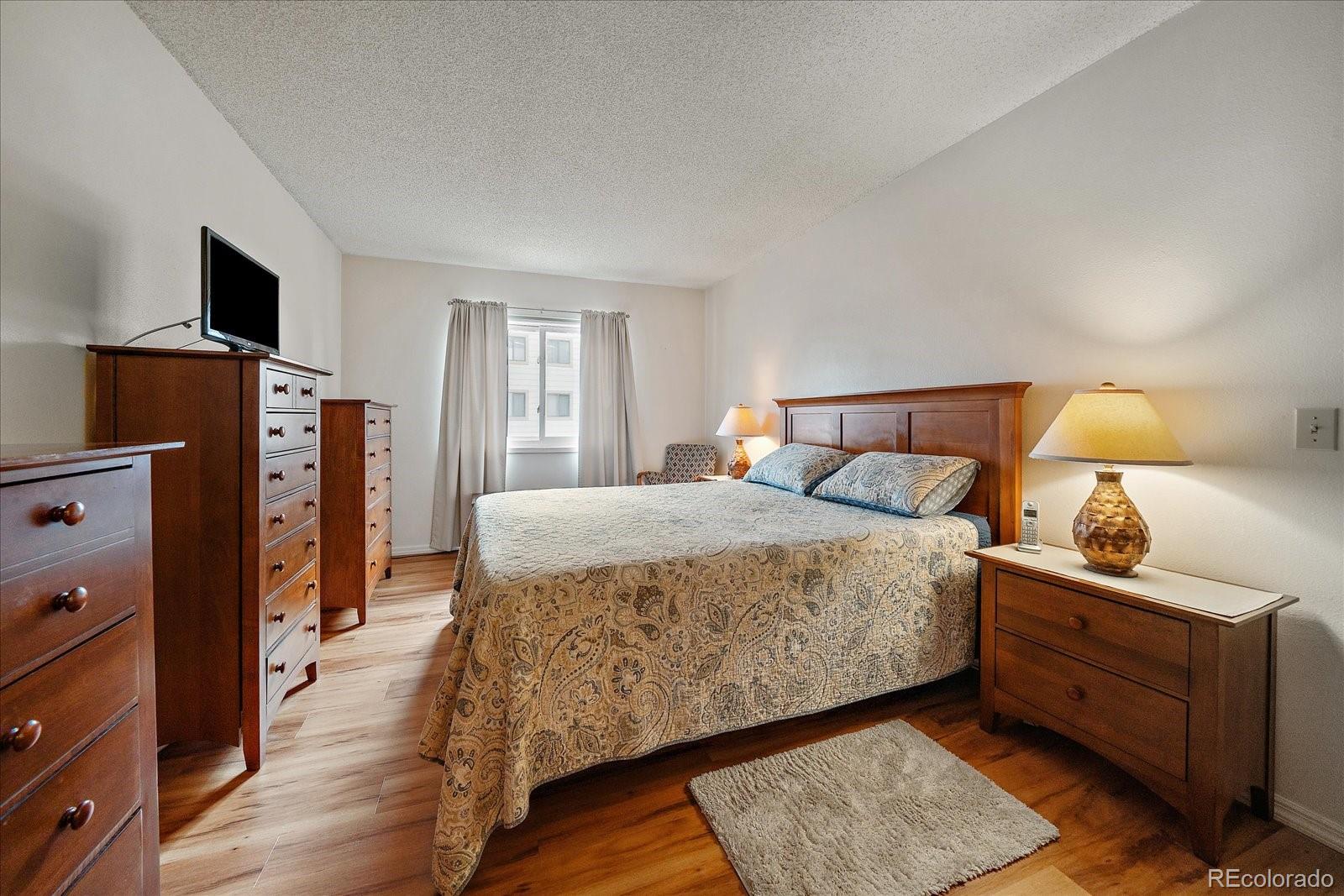 471 South Kalispell Way, Unit 101 Aurora, CO 80017 - Photo 12 of 27 a bed room with a bed and a television