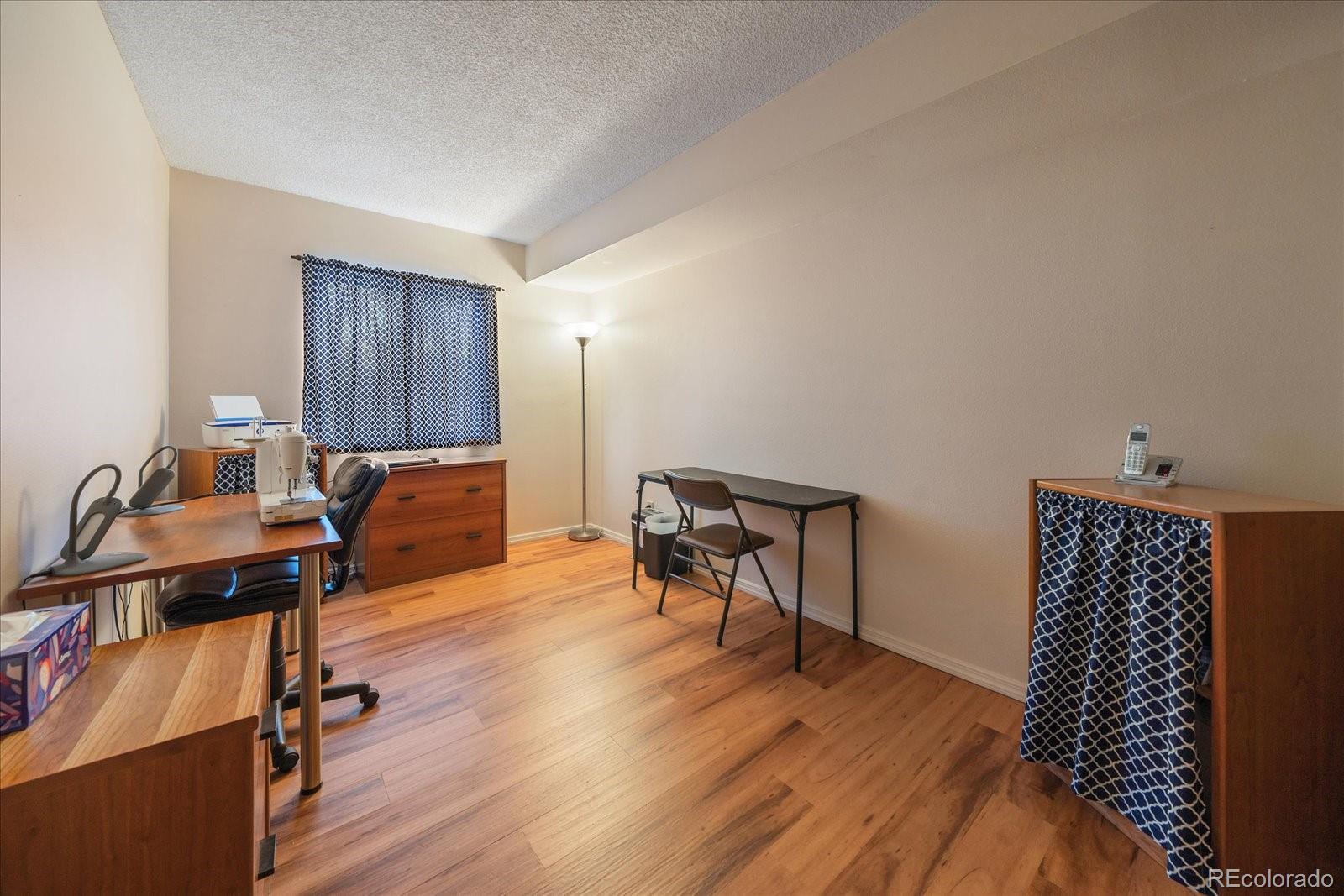 471 South Kalispell Way, Unit 101 Aurora, CO 80017 - Photo 16 of 27 a workspace with furniture and wooden floor