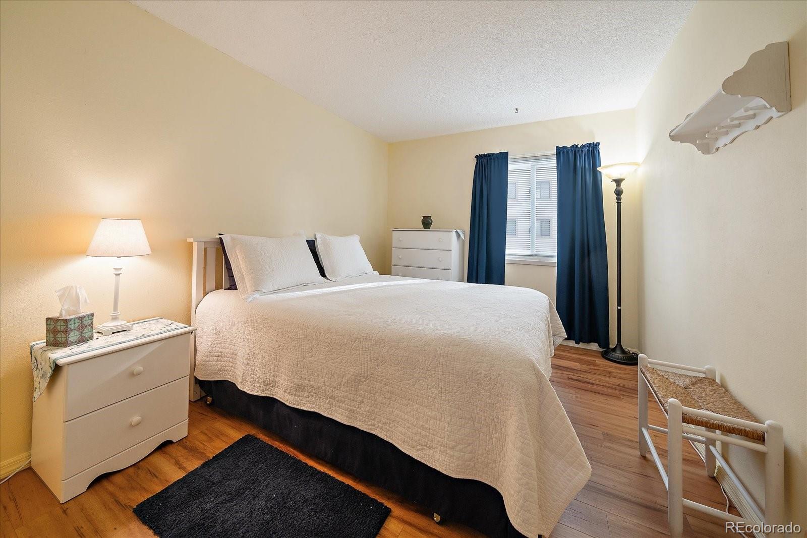 471 South Kalispell Way, Unit 101 Aurora, CO 80017 - Photo 17 of 27 a bed room with a bed and a lamp