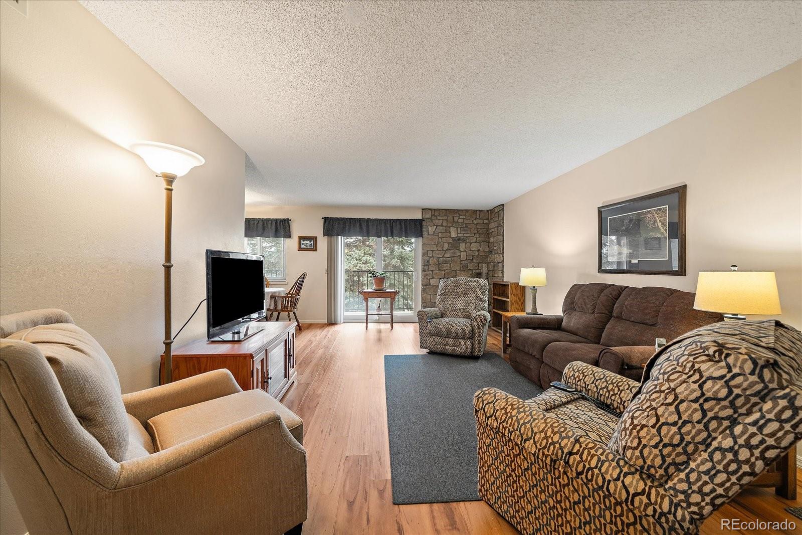 471 South Kalispell Way, Unit 101 Aurora, CO 80017 - Photo 5 of 27 a living room with furniture a couch and a flat screen tv