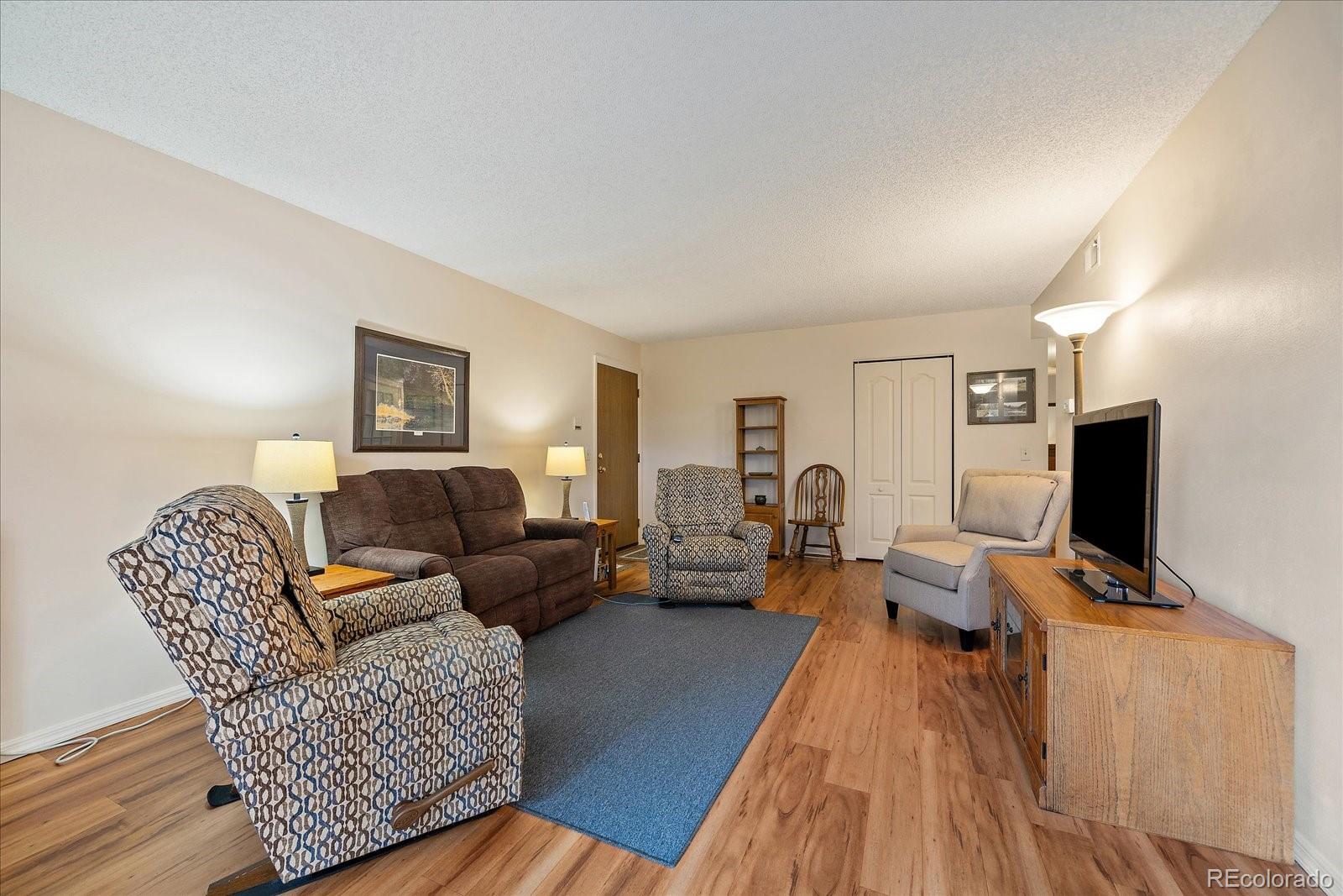 471 South Kalispell Way, Unit 101 Aurora, CO 80017 - Photo 6 of 27 a living room with furniture and a flat screen tv