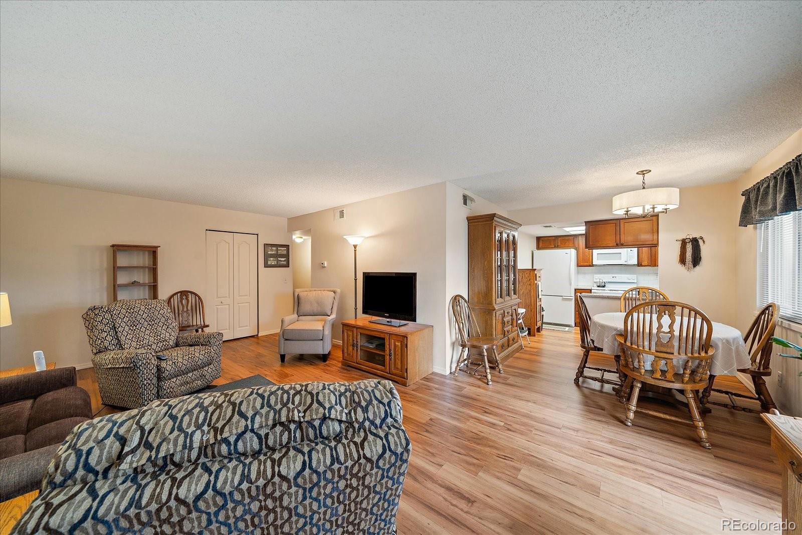 471 South Kalispell Way, Unit 101 Aurora, CO 80017 - Photo 7 of 27 a bedroom with furniture wooden floor and a flat screen tv