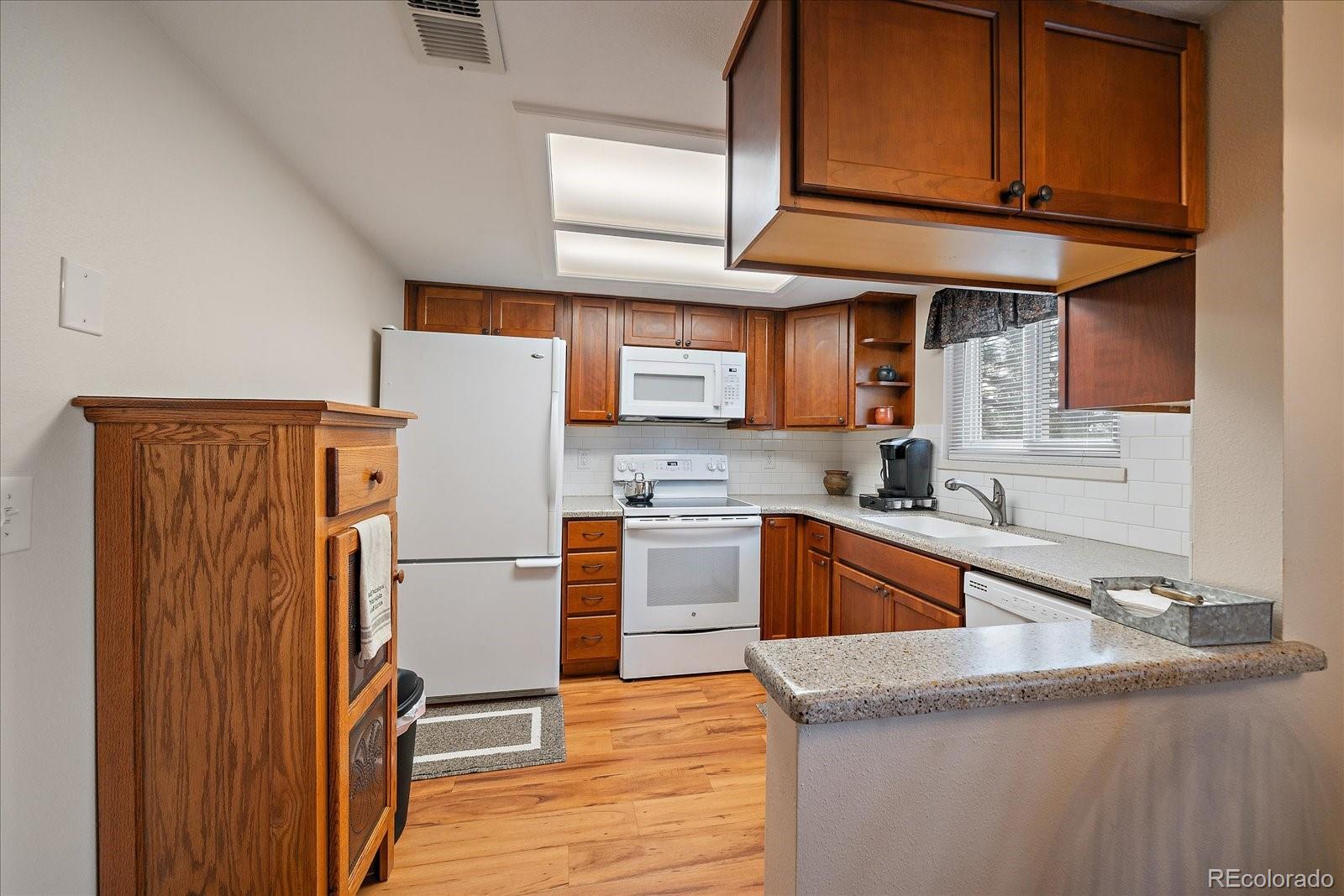 471 South Kalispell Way, Unit 101 Aurora, CO 80017 - Photo 9 of 27 a kitchen with granite countertop stainless steel appliances and wooden cabinets