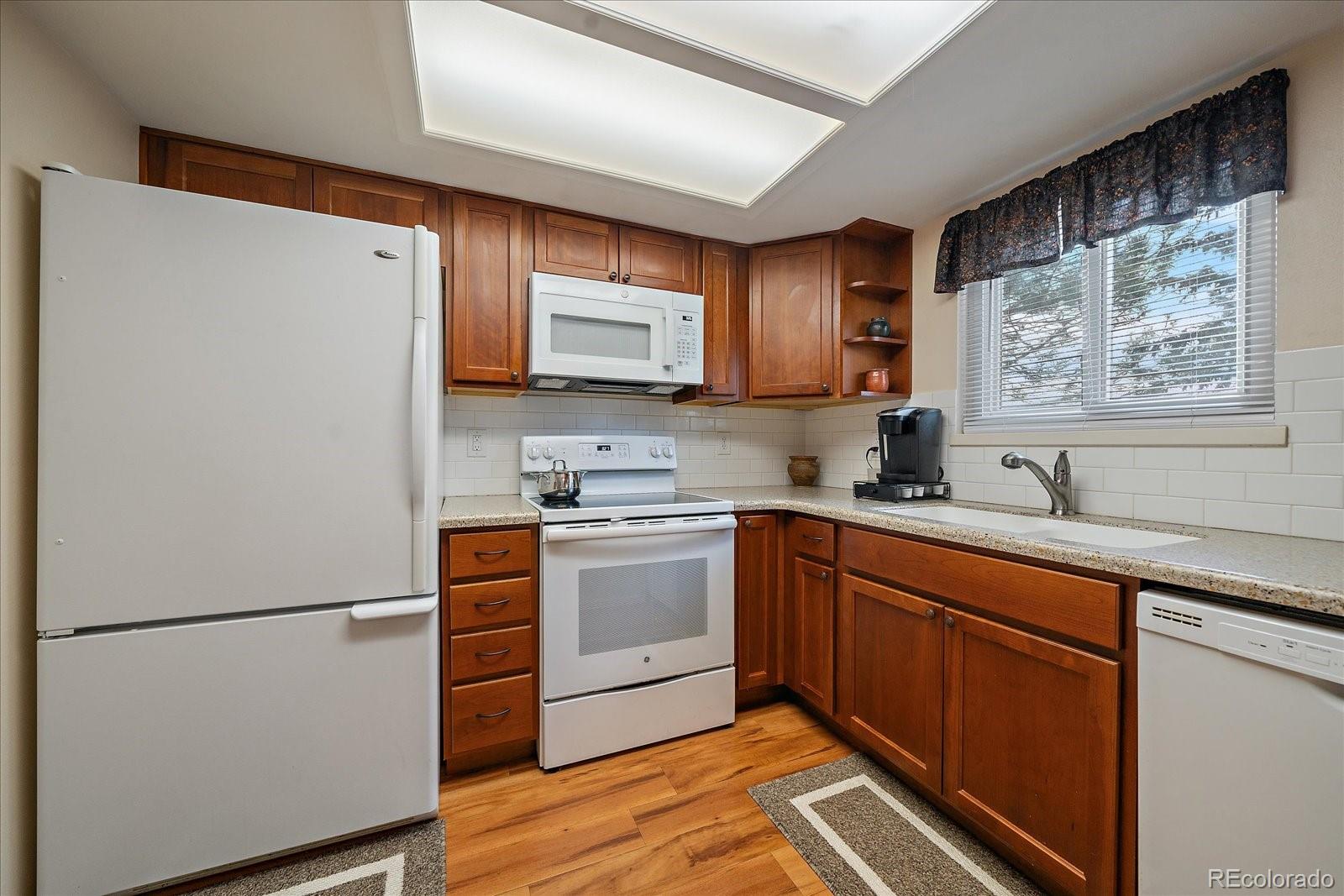 471 South Kalispell Way, Unit 101 Aurora, CO 80017 - Photo 10 of 27 a kitchen with stainless steel appliances white cabinets and a refrigerator