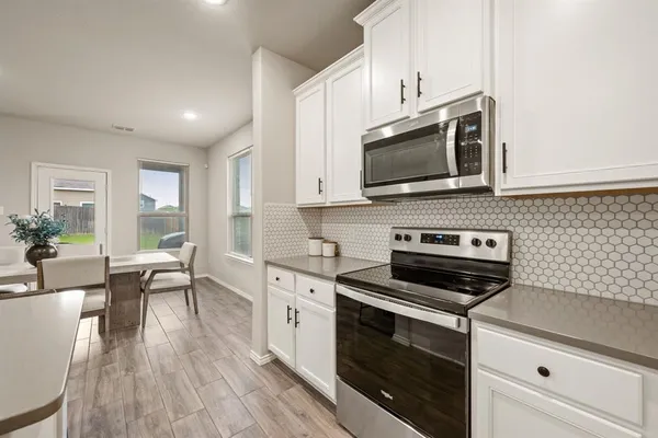 a kitchen with stainless steel appliances a stove microwave and cabinets