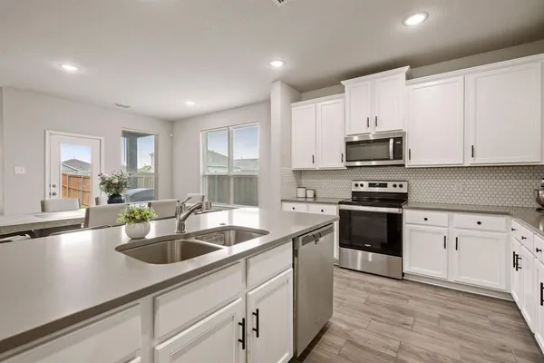 a kitchen with sink a stove and cabinets