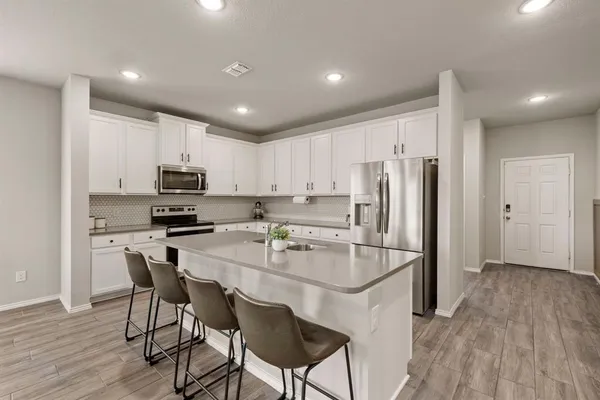 a kitchen with stainless steel appliances a refrigerator stove microwave and cabinets