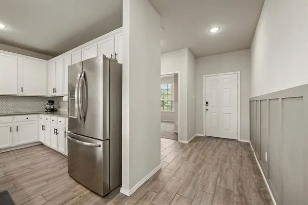 a kitchen with granite countertop stainless steel appliances a refrigerator and cabinets