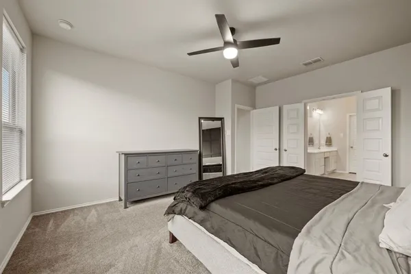 a bedroom with a bed and a ceiling fan