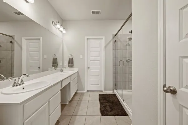 a spacious bathroom with a shower sink and mirror