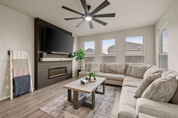 a living room with furniture a flat screen tv and a large window