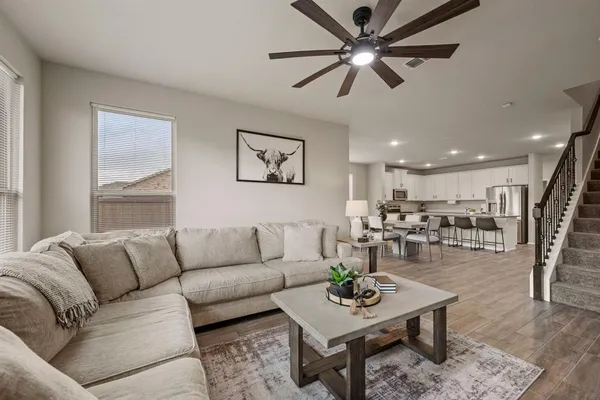 a living room with furniture and a view of kitchen