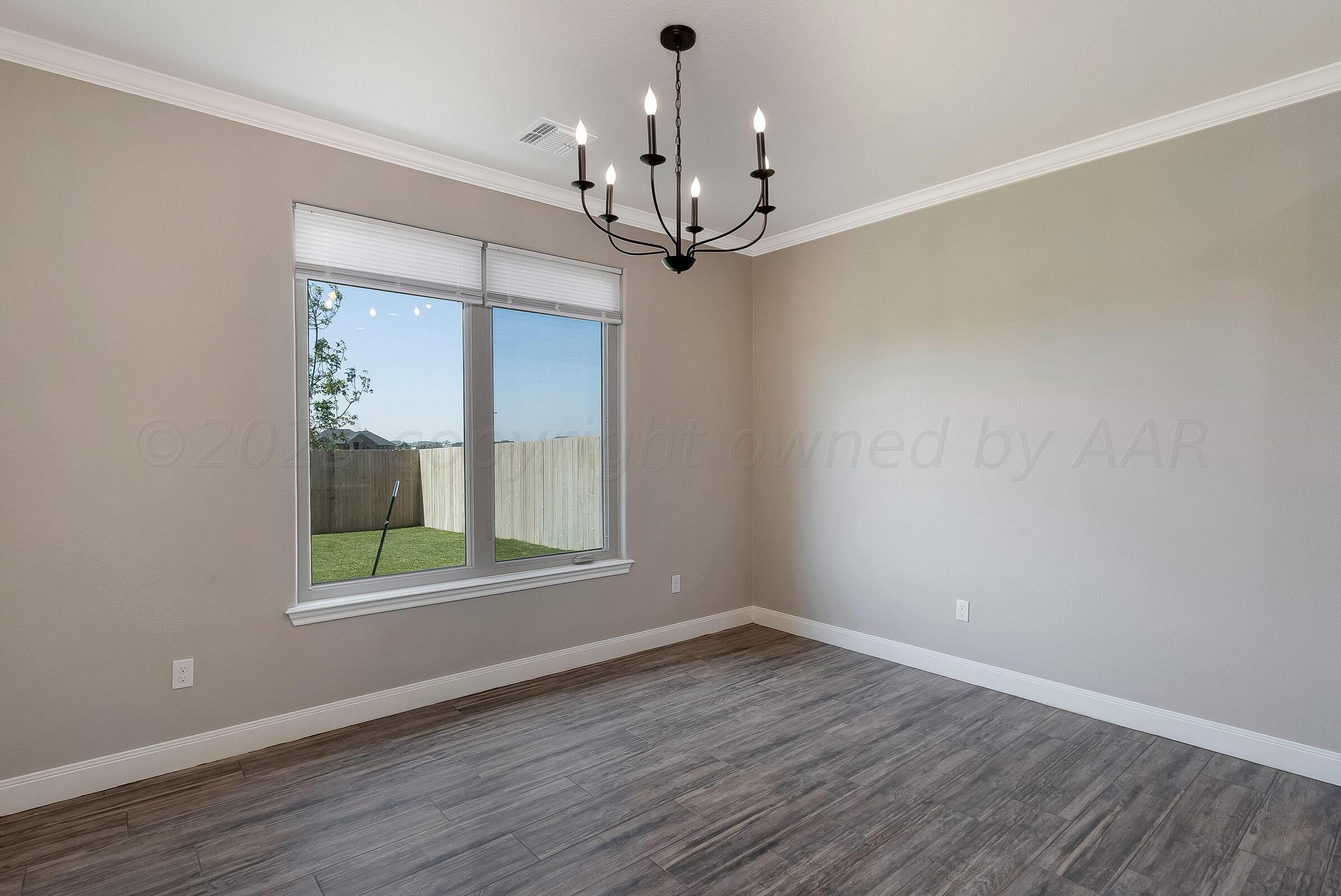 9289 Clinton Glen Road Amarillo, TX 79119 - Photo 12 of 27 a view of a room with wooden floor chandelier and windows