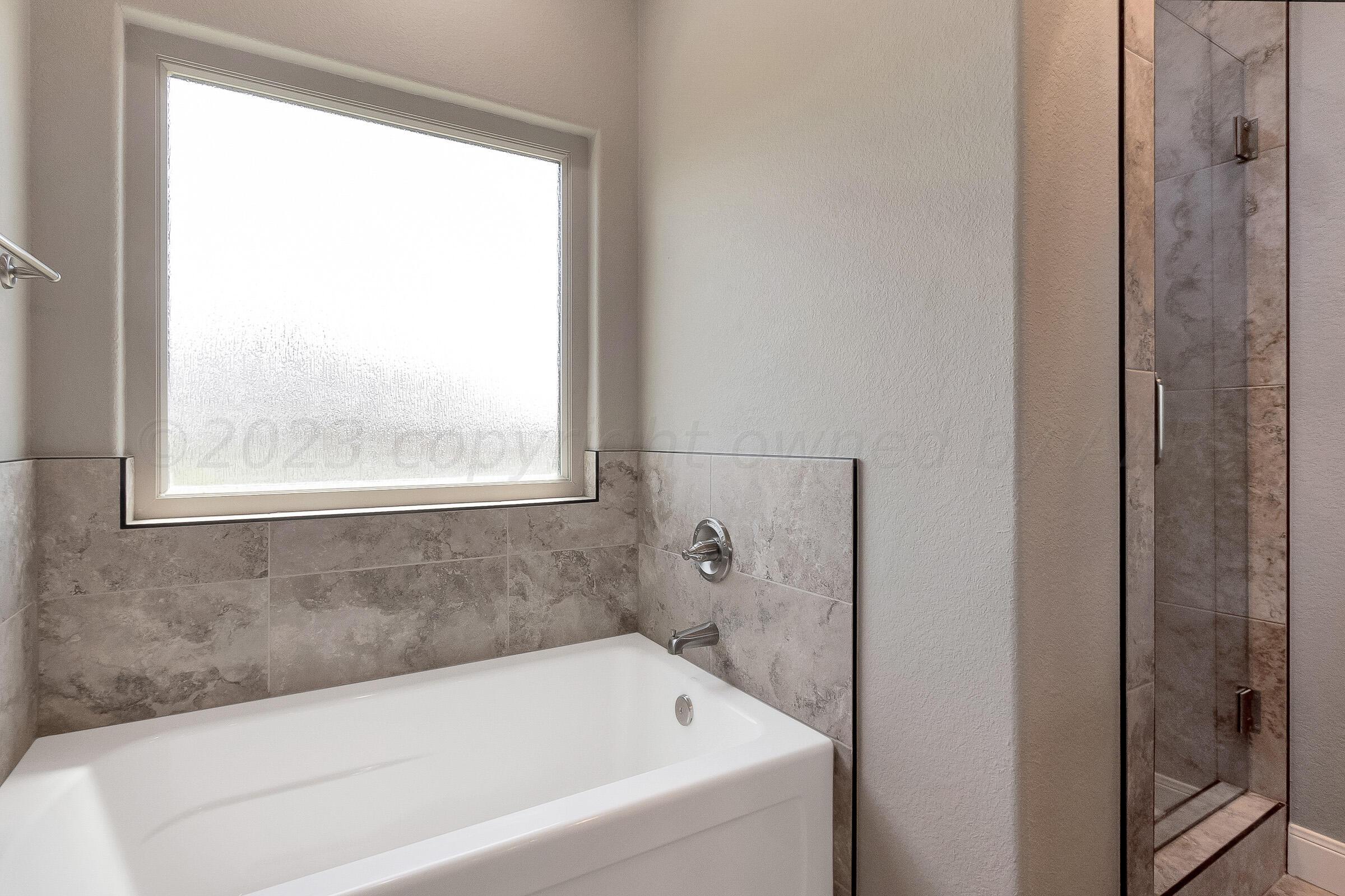 9289 Clinton Glen Road Amarillo, TX 79119 - Photo 15 of 27 a white bath tub sitting next to a window