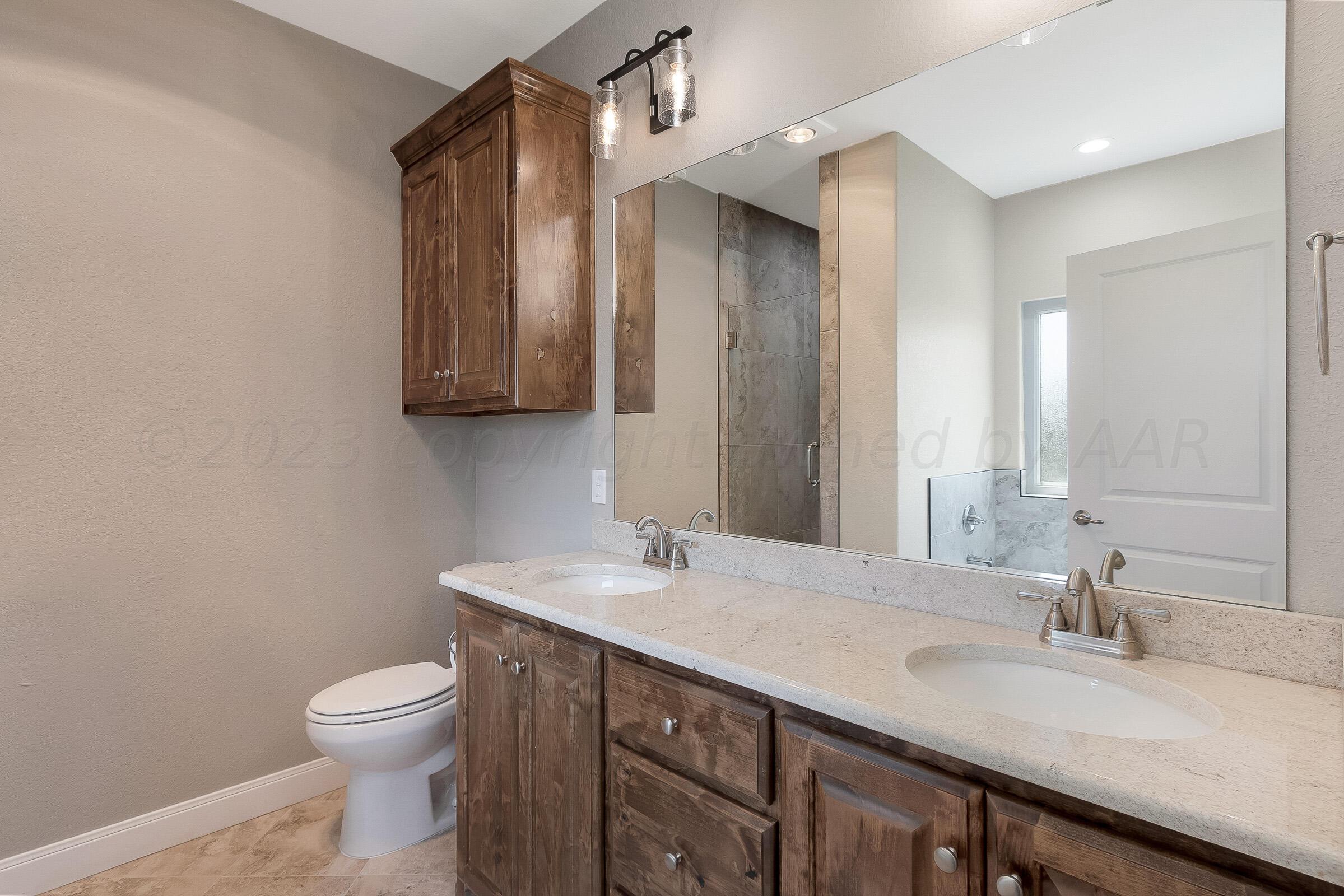 9289 Clinton Glen Road Amarillo, TX 79119 - Photo 16 of 27 a bathroom with a sink and a toilet