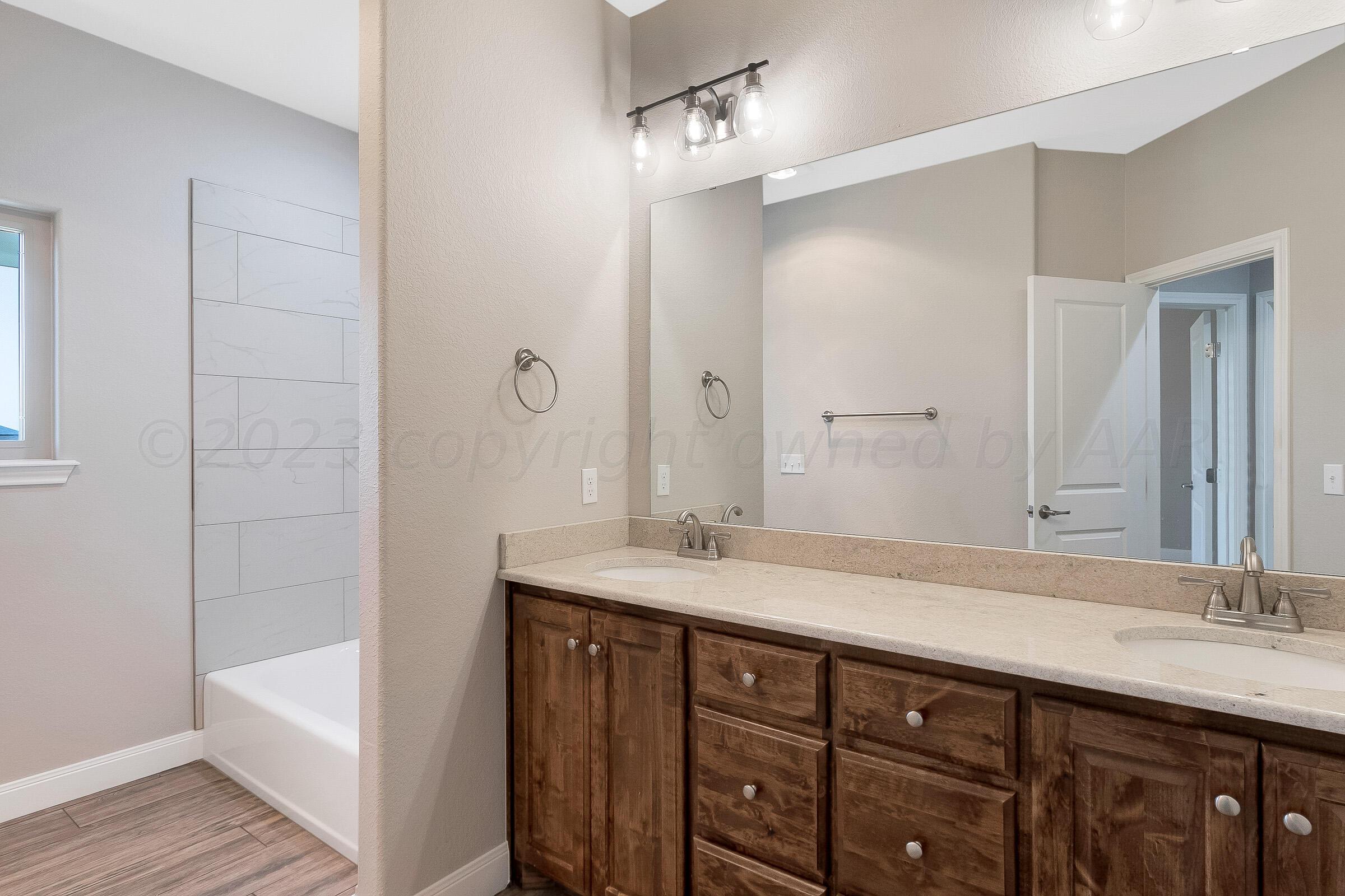 9289 Clinton Glen Road Amarillo, TX 79119 - Photo 18 of 27 a bathroom with a double vanity sink and a mirror