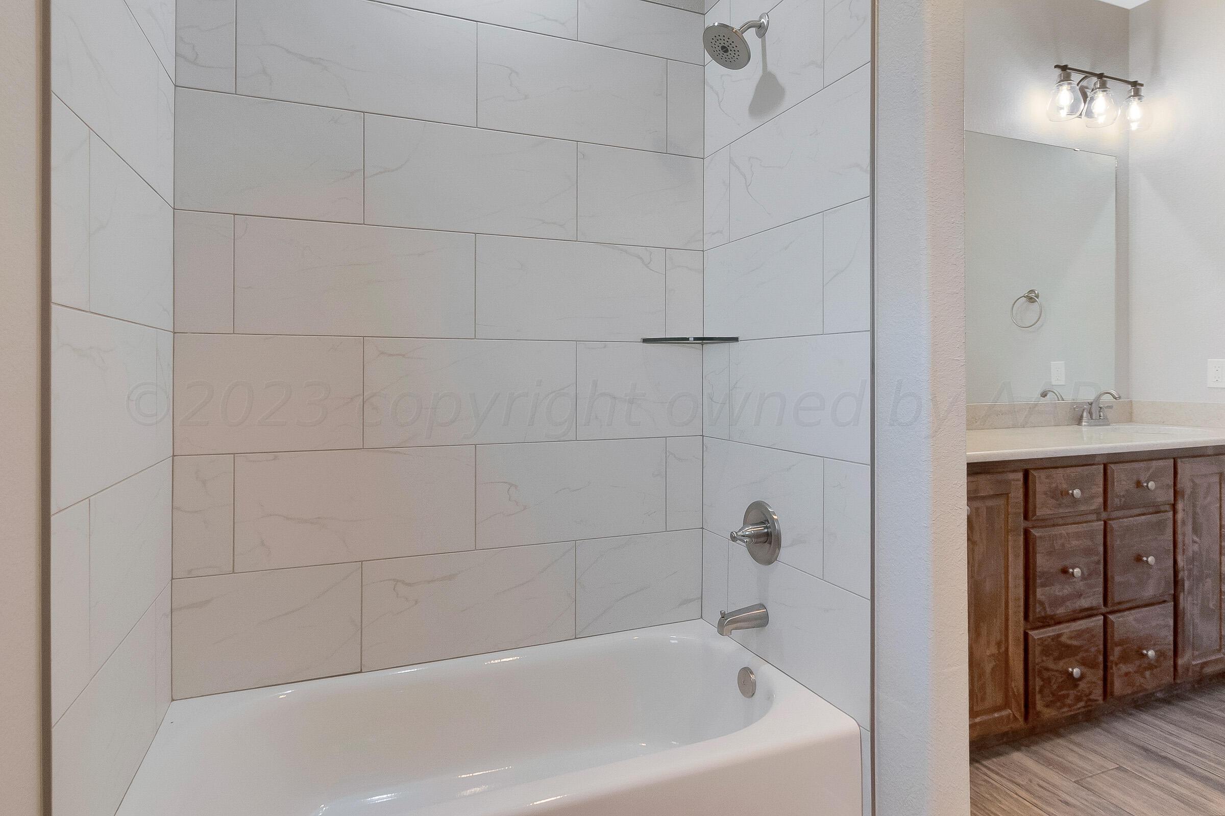 9289 Clinton Glen Road Amarillo, TX 79119 - Photo 19 of 27 a bathroom with a bathtub and a shower