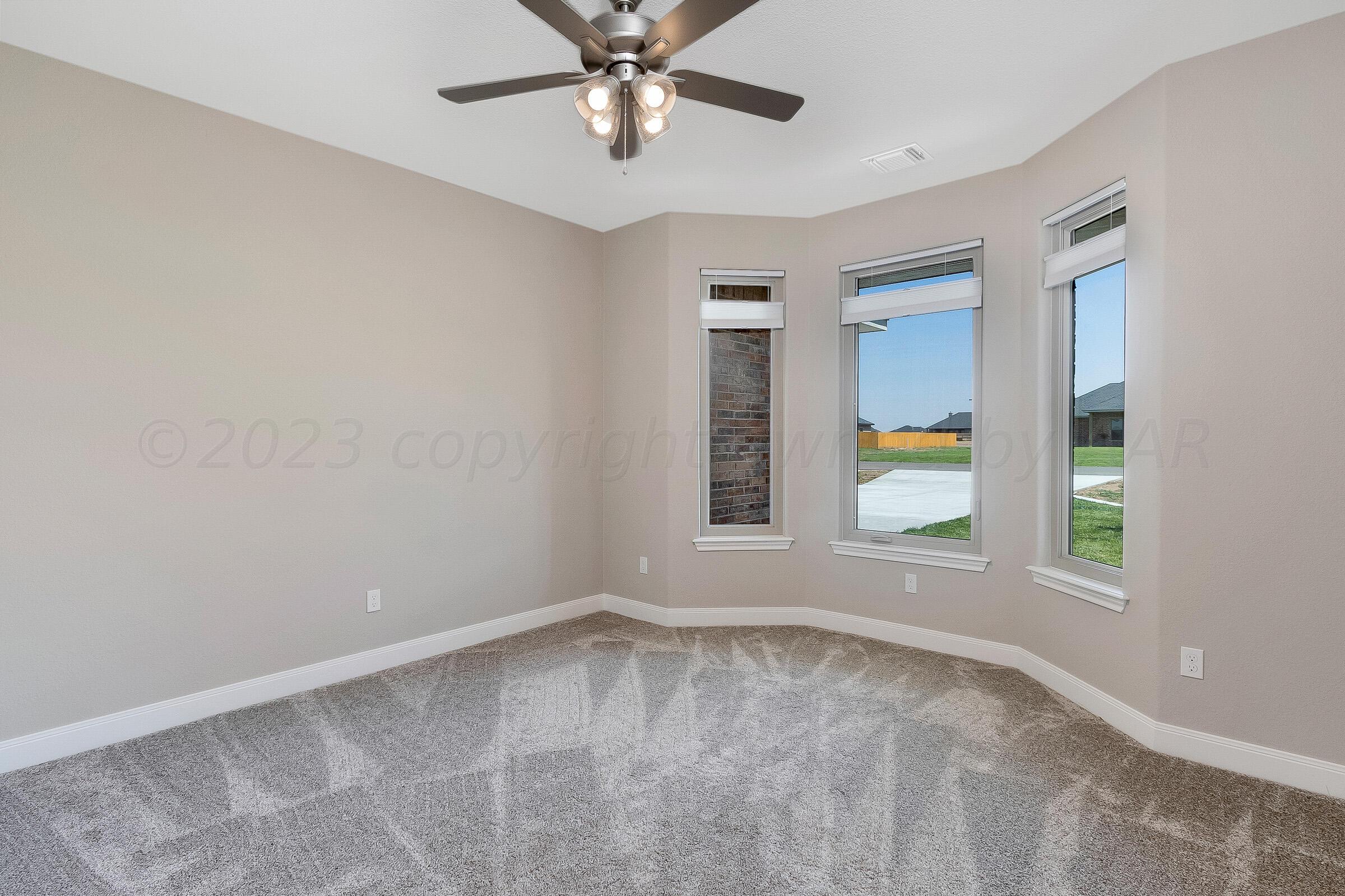 9289 Clinton Glen Road Amarillo, TX 79119 - Photo 21 of 27 an empty room with windows and ceiling fan
