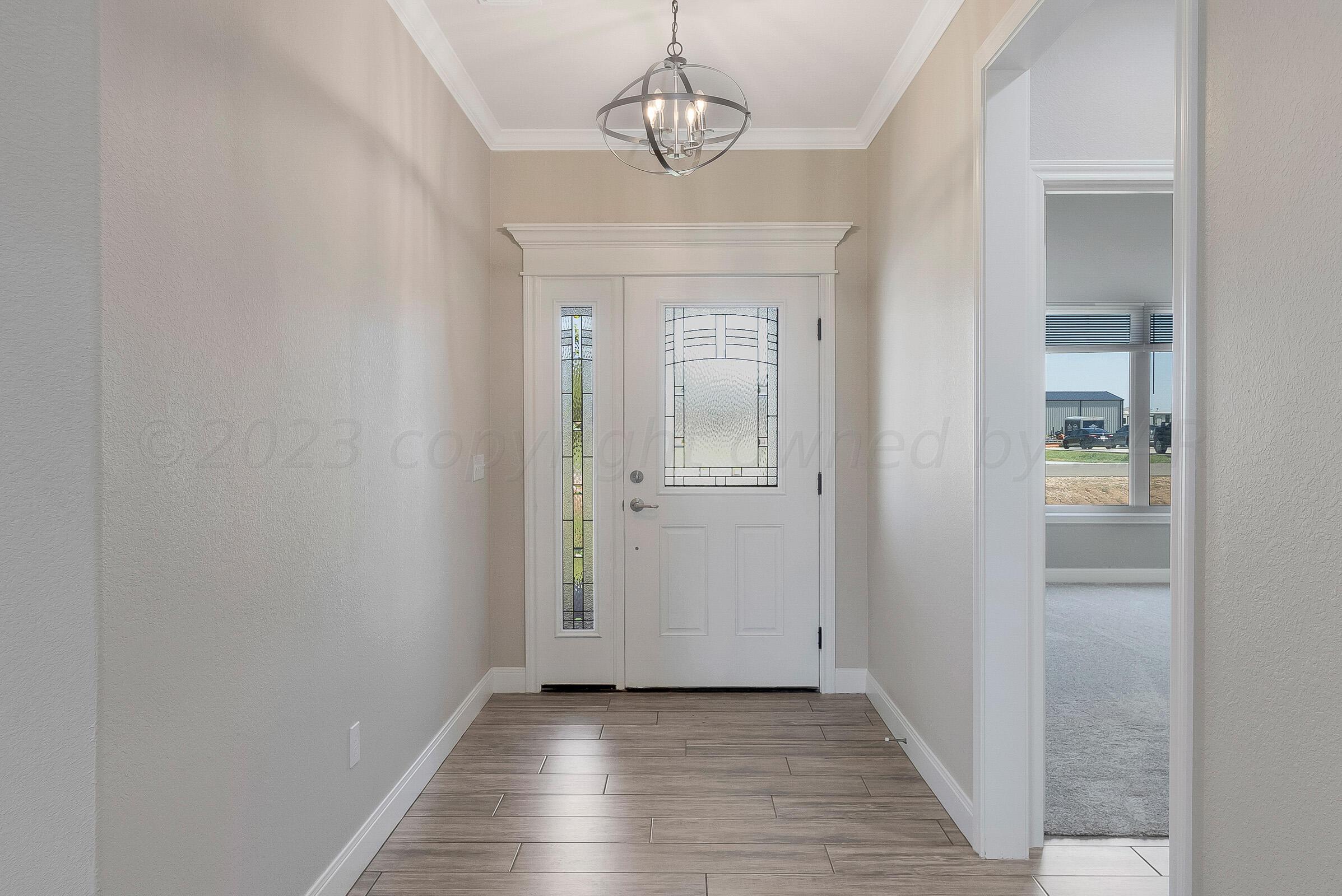 9289 Clinton Glen Road Amarillo, TX 79119 - Photo 3 of 27 a view of a hallway with wooden floor and a bathroom