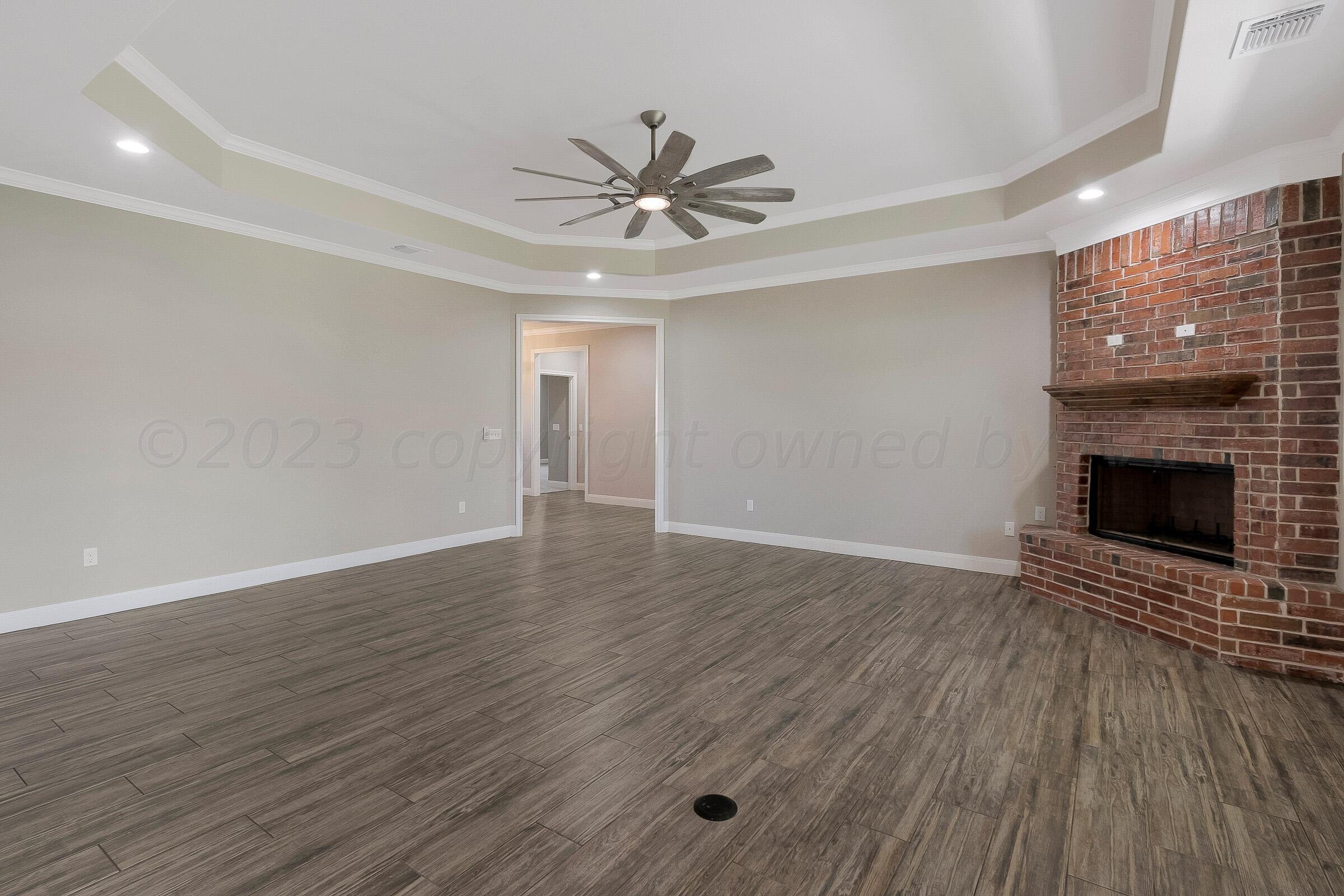 9289 Clinton Glen Road Amarillo, TX 79119 - Photo 5 of 27 a view of an empty room with wooden floor fireplace and a window