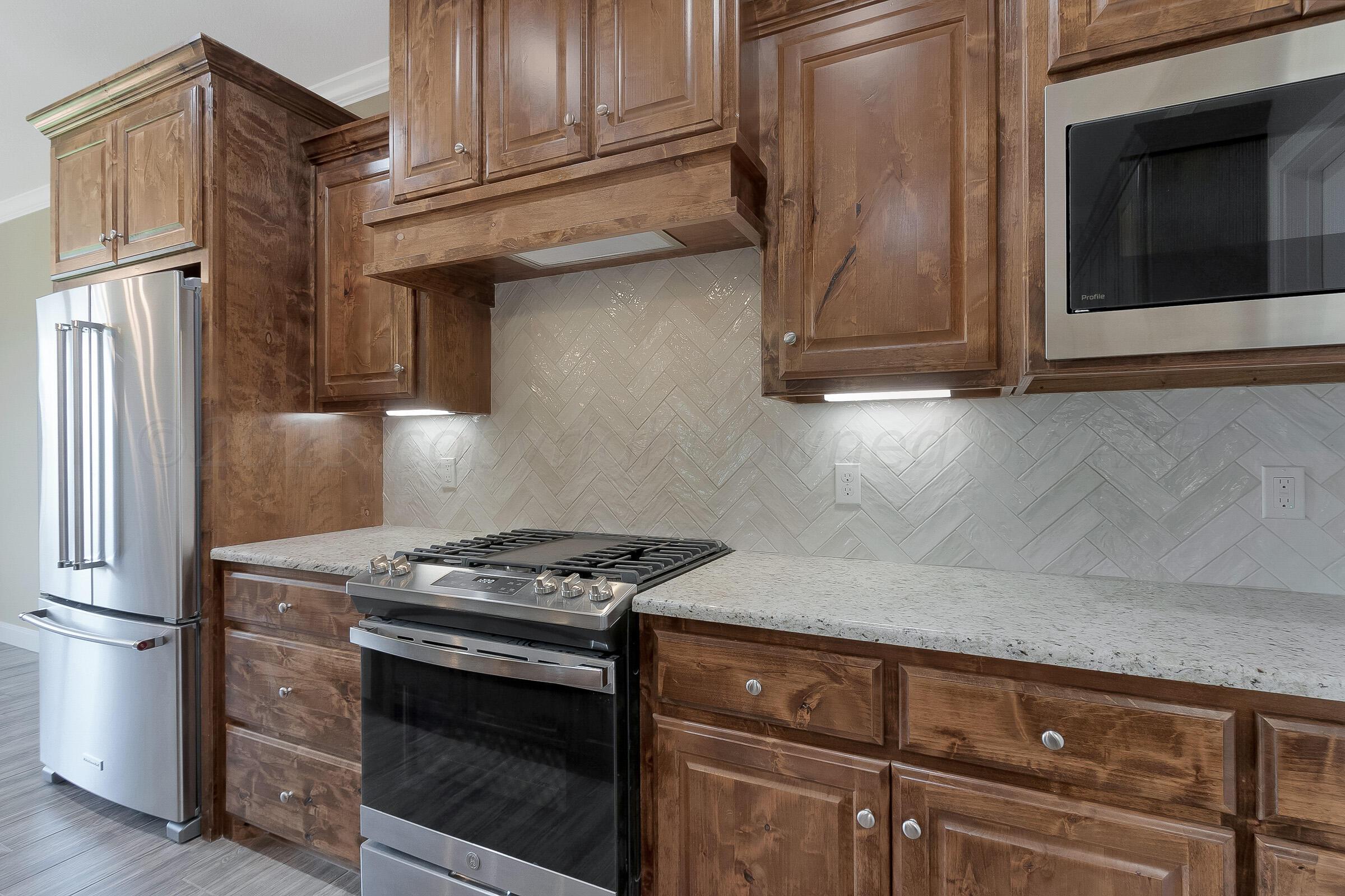 9289 Clinton Glen Road Amarillo, TX 79119 - Photo 8 of 27 a kitchen with granite countertop a stove and a refrigerator