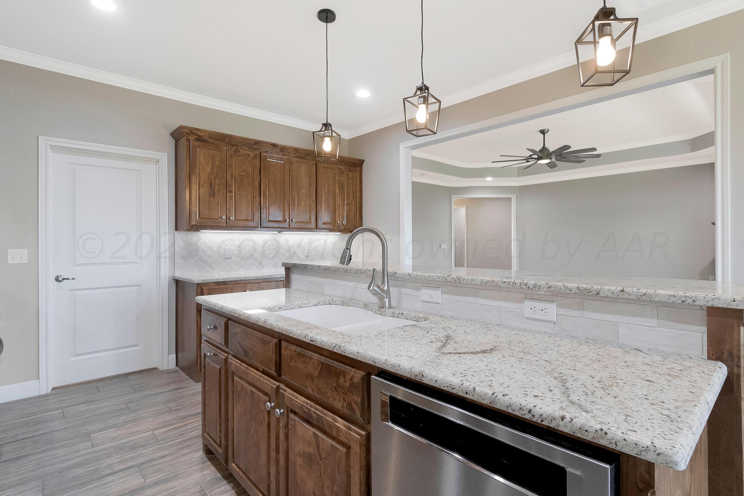 9289 Clinton Glen Road Amarillo, TX 79119 - Photo 9 of 27 a kitchen with a sink a counter space cabinets and wooden floor