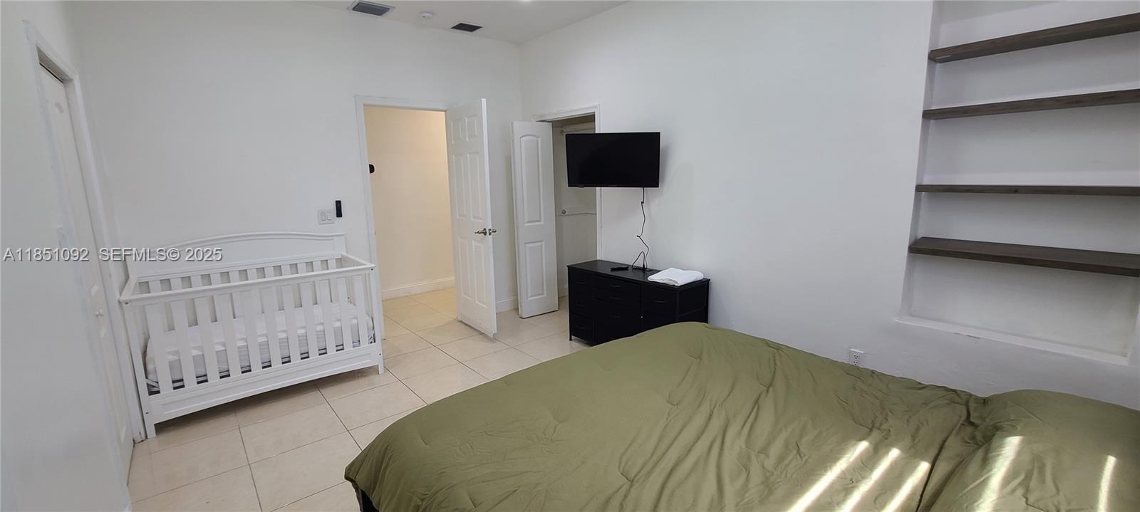 1721 Southwest 24th Terrace Miami, FL 33145 - Photo 43 of 80 a bedroom with a bed and a flat tv screen on dresser