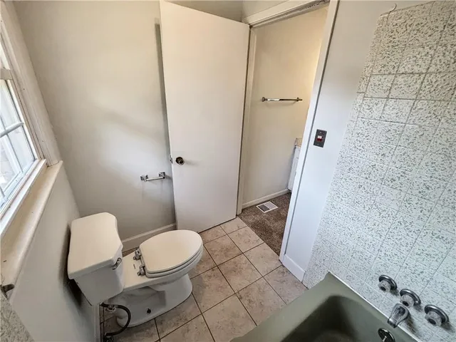 a bathroom with a sink a toilet a mirror and shower