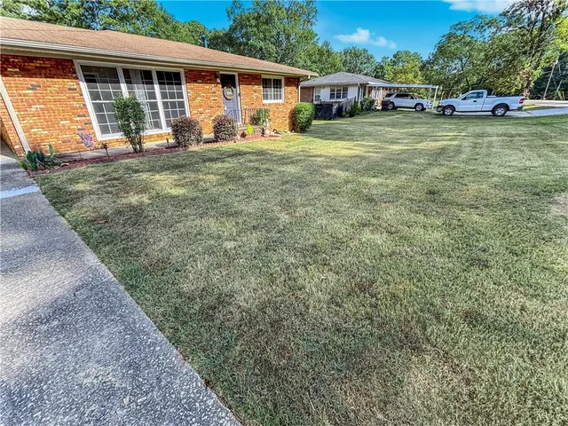 a view of a house with a yard and sitting area
