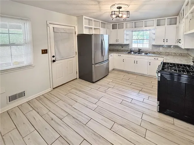 a kitchen with granite countertop a refrigerator and a sink