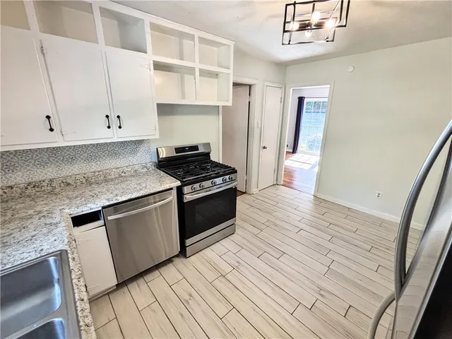 a kitchen with granite countertop a stove and cabinets
