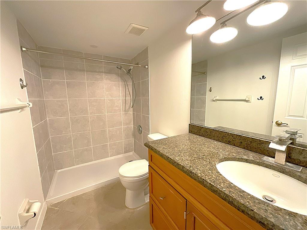 3002 Sandpiper Bay Circle, Unit A103 Naples, FL 34112 - Photo 17 of 25 a bathroom with a granite countertop sink toilet mirror and shower