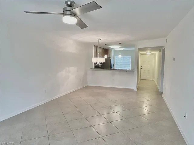 an empty room with a ceiling fan and window