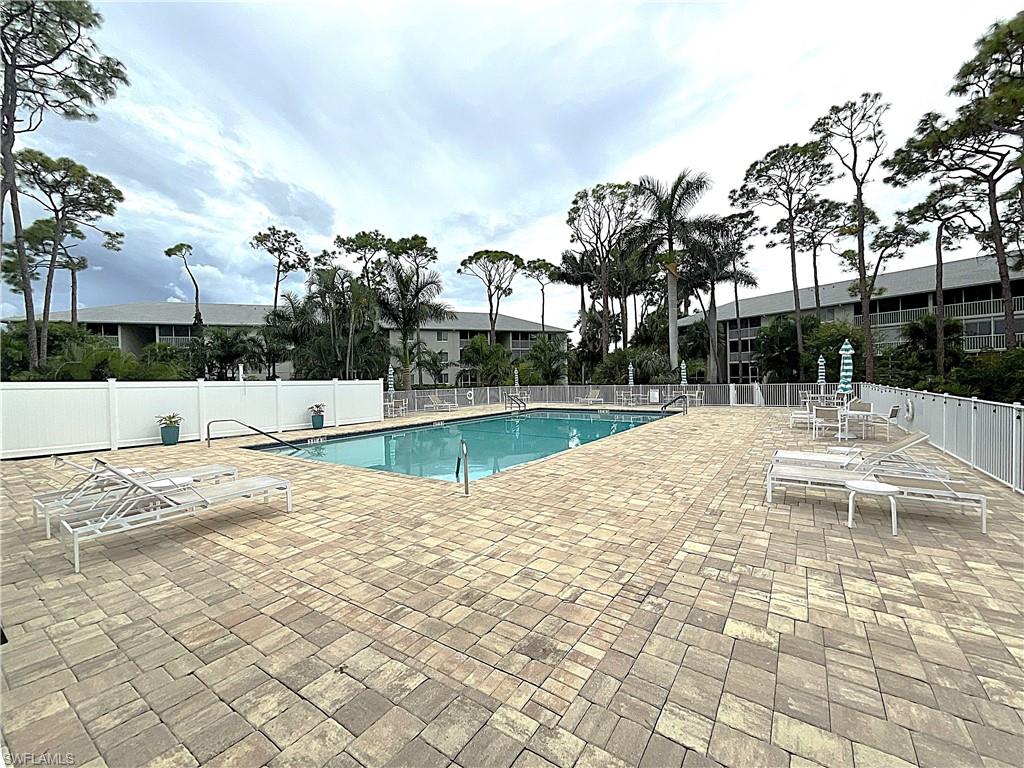 3002 Sandpiper Bay Circle, Unit A103 Naples, FL 34112 - Photo 22 of 25 a view of a swimming pool with a patio