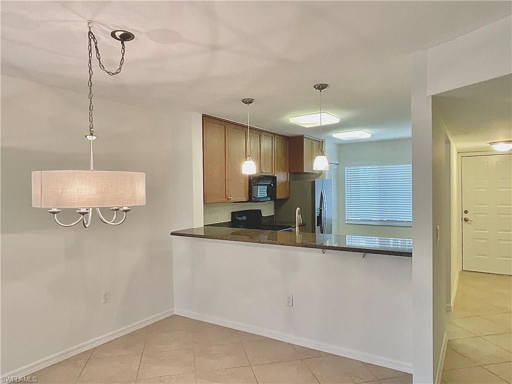 3002 Sandpiper Bay Circle, Unit A103 Naples, FL 34112 - Photo 3 of 25 a kitchen with stainless steel appliances granite countertop a sink and a refrigerator