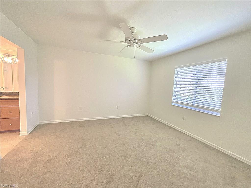 3002 Sandpiper Bay Circle, Unit A103 Naples, FL 34112 - Photo 10 of 25 an empty room with windows and fan