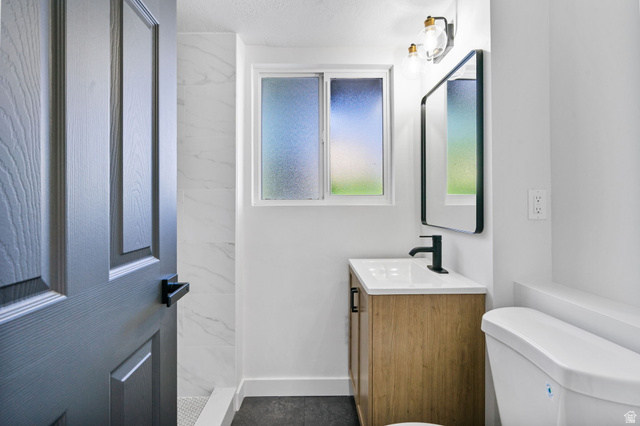 432 Calnette Drive Sandy, UT 84070 - Photo 26 of 48 Bathroom featuring a light wood-finish vanity with an integrated white sink, a matte black faucet, and a rectangular framed mirror