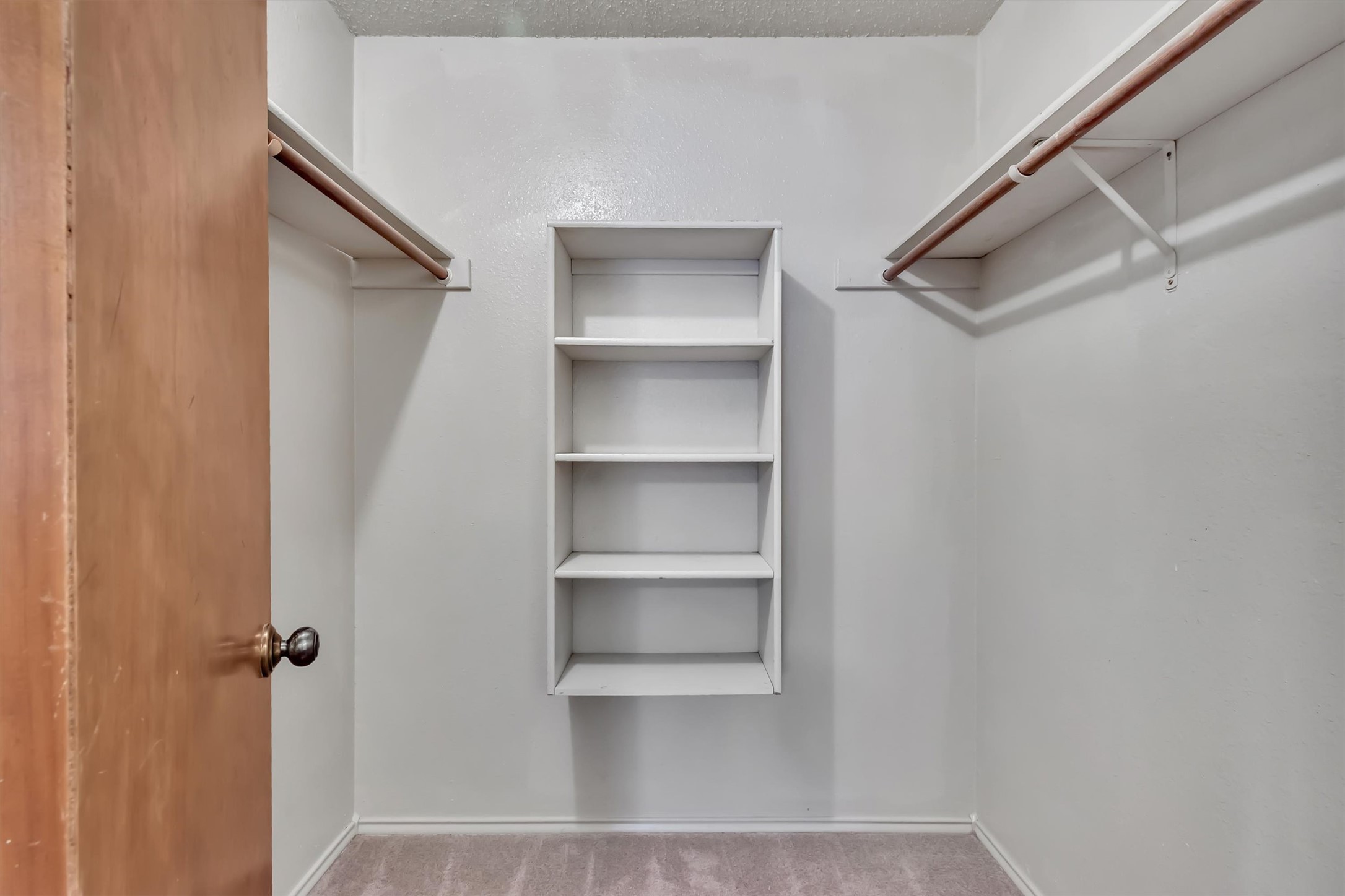 7802 Topawa Cove, Unit B Austin, TX 78729 - Photo 22 of 32 Ample storage solutions abound in this well-appointed closet, featuring built-in shelving and hanging rods.