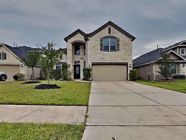 a front view of a house with a yard and garage