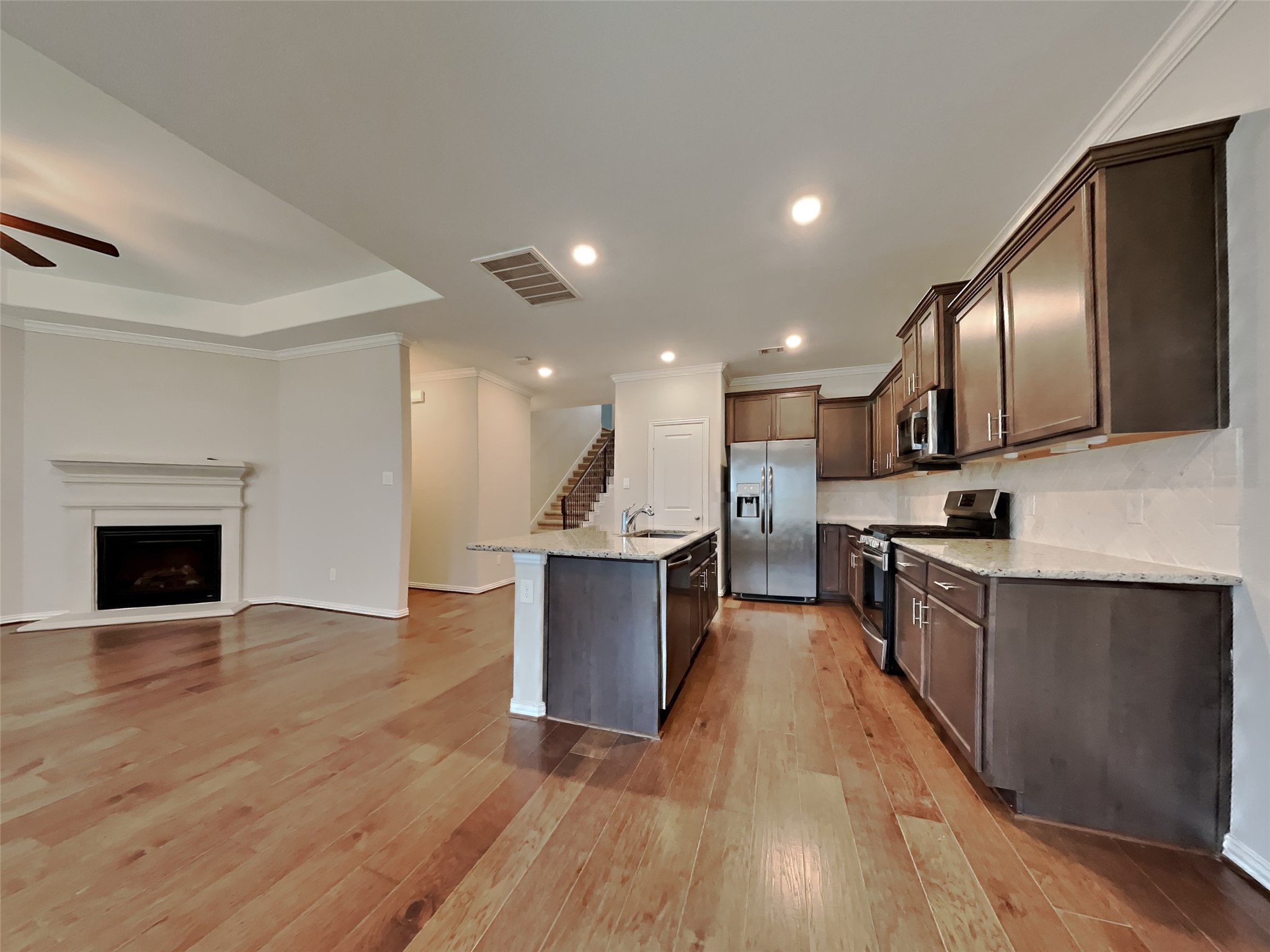 3434 Stablewood Grove Lane Spring, TX 77386 - Photo 5 of 22 a large kitchen with stainless steel appliances granite countertop a stove top oven a sink dishwasher a microwave oven and a dining table with wooden floor
